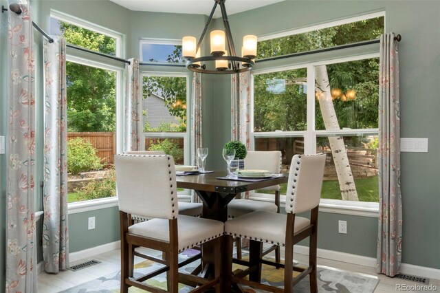 sunroom / solarium featuring visible vents and a chandelier