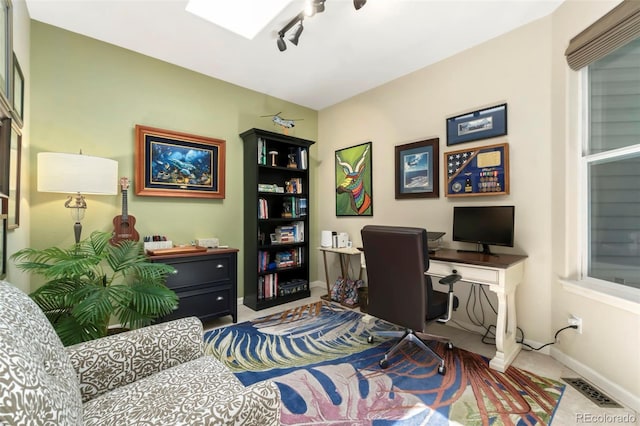 office with visible vents, baseboards, a skylight, and track lighting