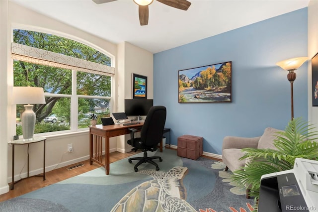 office space with visible vents, a ceiling fan, baseboards, and wood finished floors