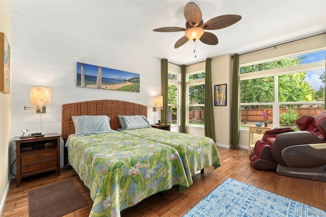 bedroom featuring baseboards, wood-type flooring, and ceiling fan