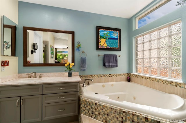 bathroom with a tub with jets and vanity