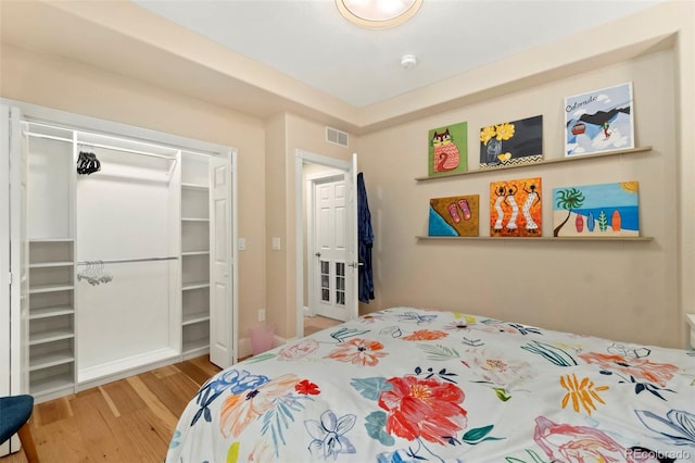 bedroom with visible vents, a closet, and wood finished floors