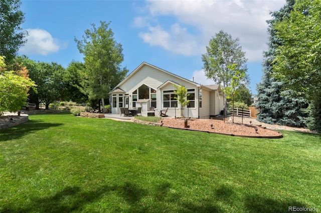 back of house with a lawn and a patio