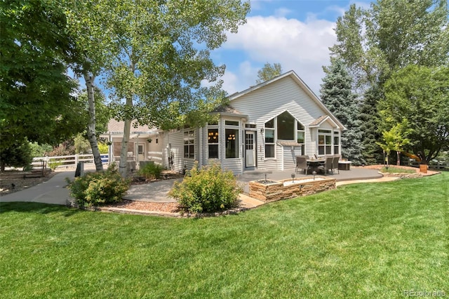 back of property with a yard, a patio, and fence