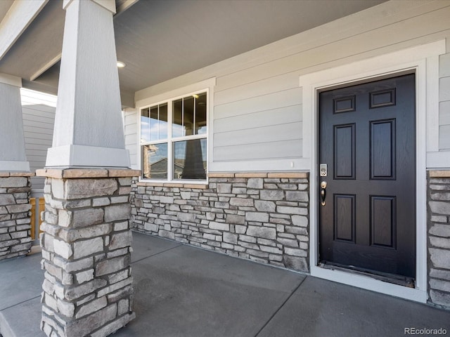 view of exterior entry with covered porch