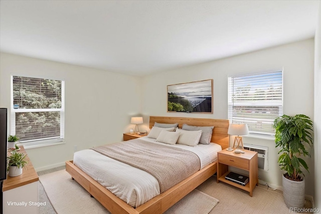 bedroom with baseboards and light colored carpet