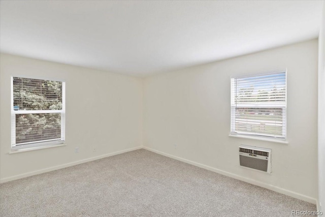 empty room with carpet, baseboards, and an AC wall unit