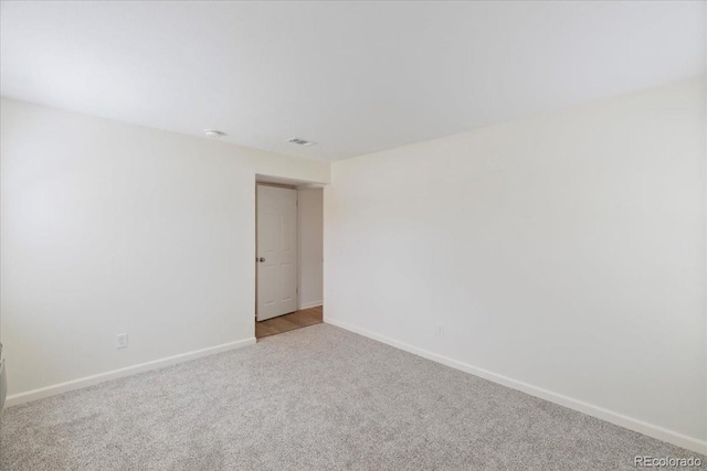 carpeted empty room with baseboards