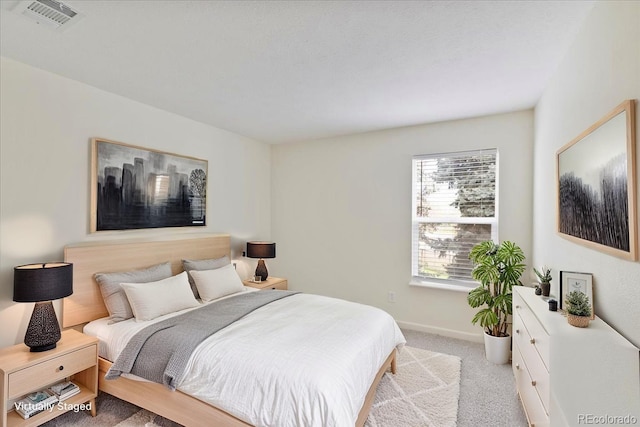 bedroom with light colored carpet and baseboards