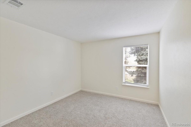 spare room with light colored carpet and baseboards