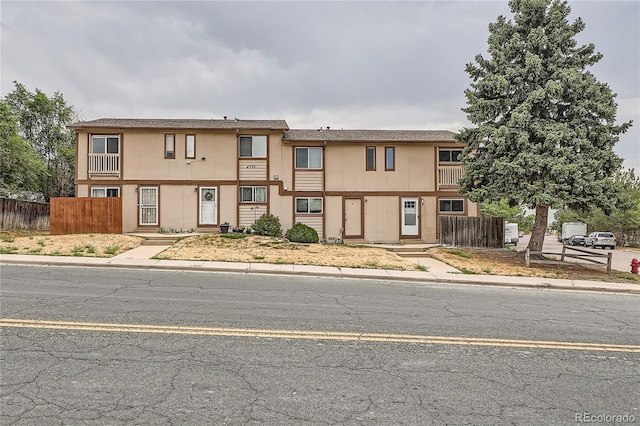 townhome / multi-family property with fence and stucco siding