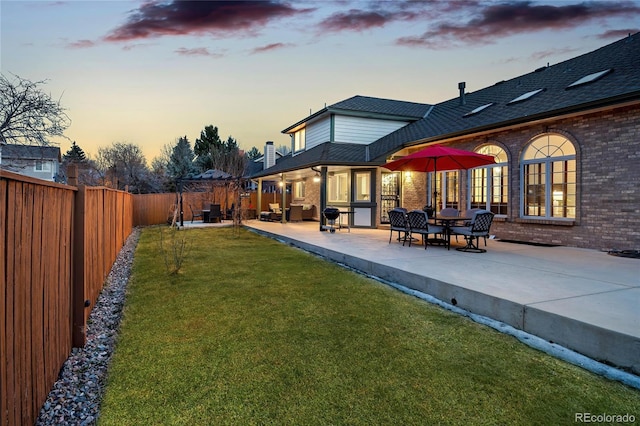 yard at dusk featuring a patio and a fenced backyard