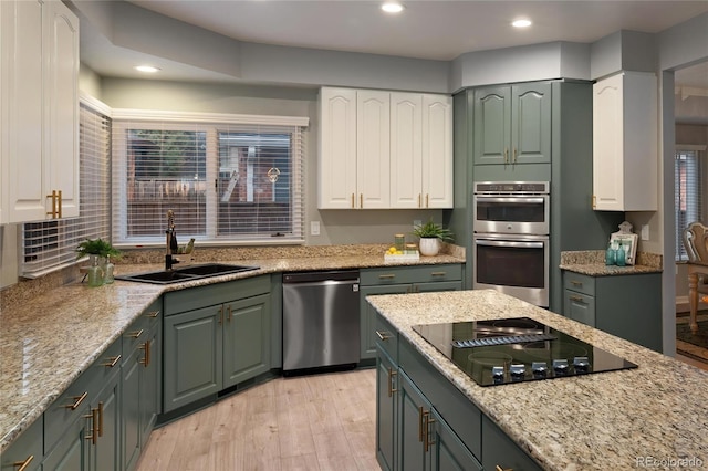 kitchen featuring light stone counters, recessed lighting, appliances with stainless steel finishes, light wood-style flooring, and white cabinets