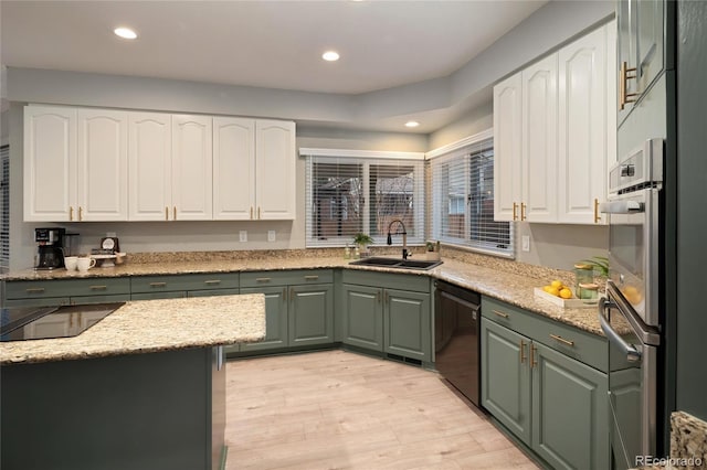 kitchen with a sink, green cabinetry, dishwasher, and white cabinetry