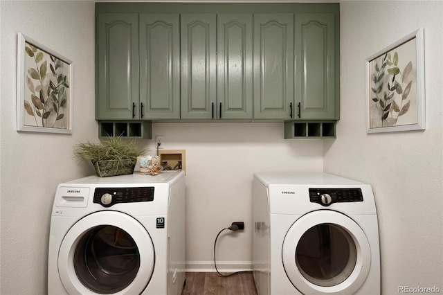 laundry area with separate washer and dryer, wood finished floors, cabinet space, and baseboards