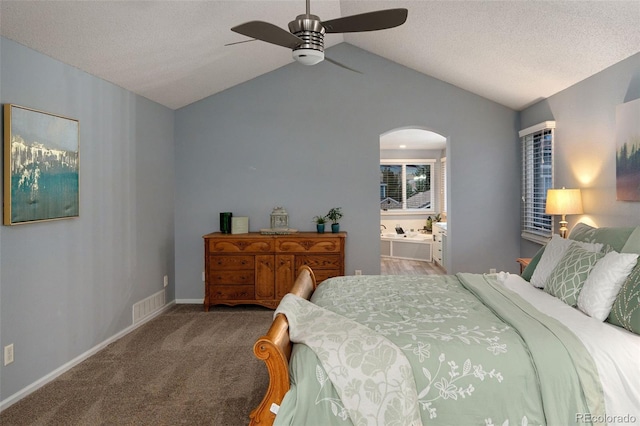 carpeted bedroom with vaulted ceiling, visible vents, arched walkways, and baseboards