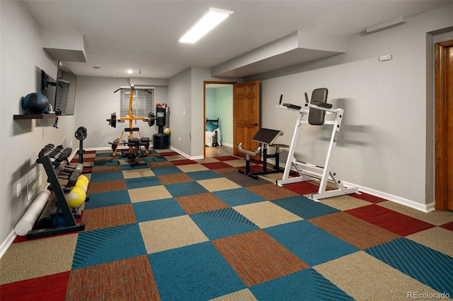 workout area featuring carpet and baseboards