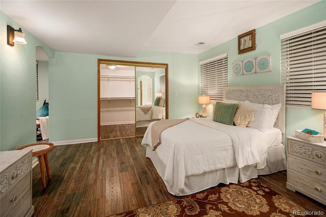 bedroom featuring wood finished floors, visible vents, a closet, and baseboards