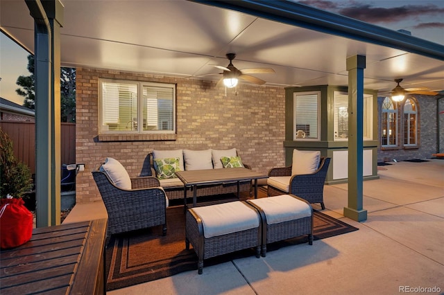 patio terrace at dusk featuring an outdoor living space, a ceiling fan, and fence