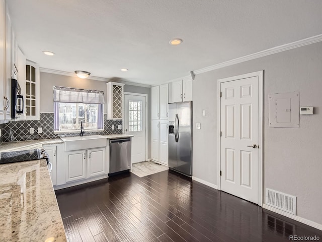 kitchen with sink, electric panel, stainless steel appliances, light stone countertops, and white cabinets