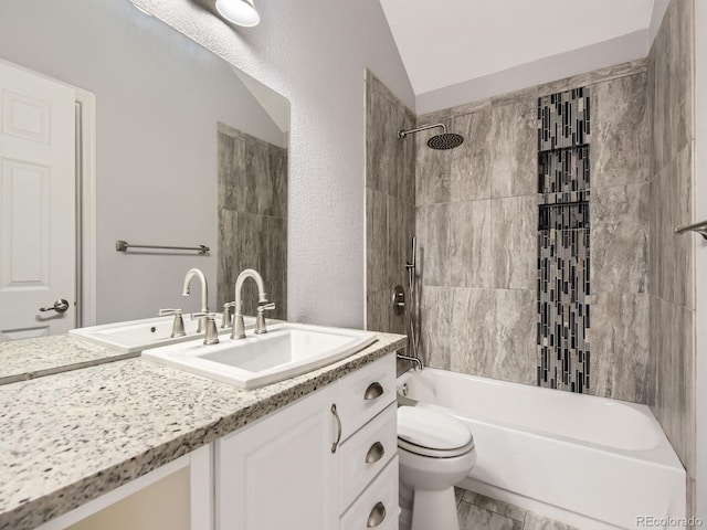 full bathroom featuring vanity, tiled shower / bath combo, vaulted ceiling, and toilet