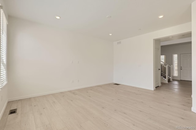 empty room featuring recessed lighting, baseboards, visible vents, and light wood-style floors