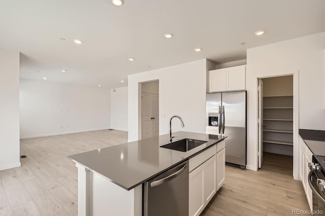 kitchen featuring light wood-style floors, a sink, appliances with stainless steel finishes, and white cabinets
