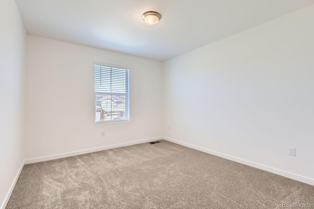 carpeted empty room featuring baseboards and visible vents