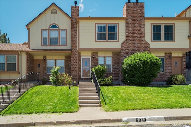 6840 Goldcrest Ct, Colorado Springs, CO 80919 - multi unit property with board and batten siding, brick siding, a chimney, and a front lawn