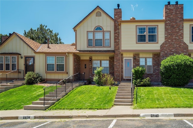 6840 Goldcrest Ct, Colorado Springs, CO 80919 - view of front of home with board and batten siding, uncovered parking, a front lawn, and stairway