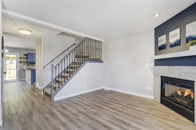 6840 Goldcrest Ct, Colorado Springs, CO 80919 - unfurnished living room with stairs, wood finished floors, baseboards, and a tile fireplace