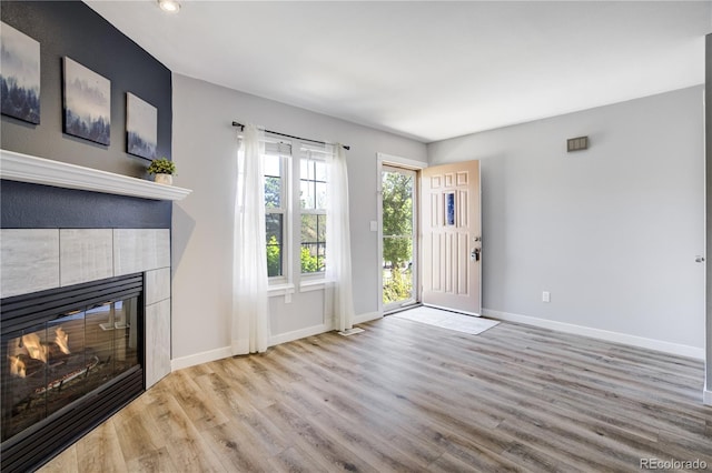 6840 Goldcrest Ct, Colorado Springs, CO 80919 - unfurnished living room featuring wood finished floors, a tile fireplace, baseboards, and recessed lighting