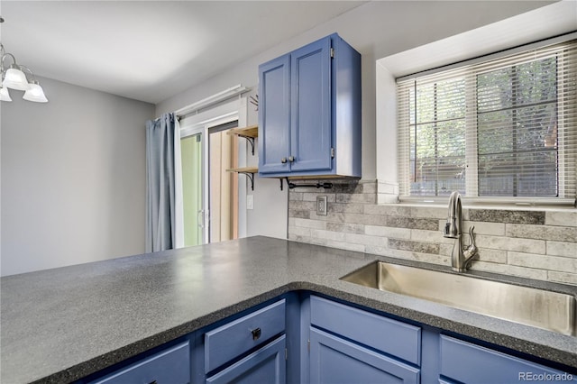 6840 Goldcrest Ct, Colorado Springs, CO 80919 - kitchen with blue cabinets, dark countertops, a sink, and tasteful backsplash