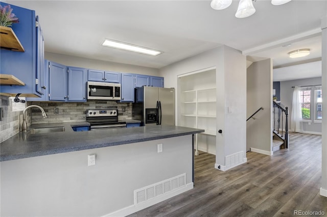 6840 Goldcrest Ct, Colorado Springs, CO 80919 - kitchen with appliances with stainless steel finishes, a sink, blue cabinetry, a peninsula, and tasteful backsplash