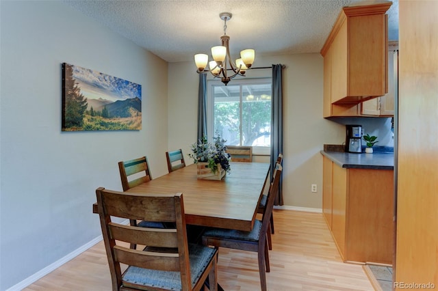 6775 Coors Ct, Arvada, CO 80004 - dining area featuring a chandelier, light wood-style flooring, and a textured ceiling