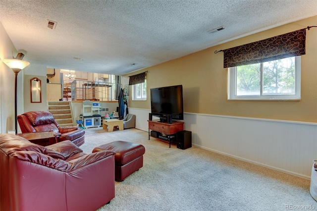 6775 Coors Ct, Arvada, CO 80004 - living room featuring carpet floors, a textured ceiling, stairway, a chandelier, and wainscoting