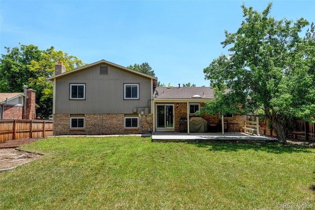 6775 Coors Ct, Arvada, CO 80004 - rear view of property with a patio, a fenced backyard, a chimney, and brick siding
