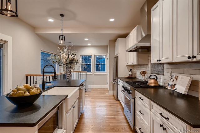 kitchen featuring white cabinets, pendant lighting, stainless steel appliances, and a center island with sink