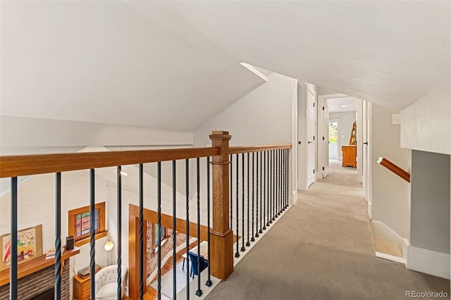 hallway featuring light carpet and vaulted ceiling