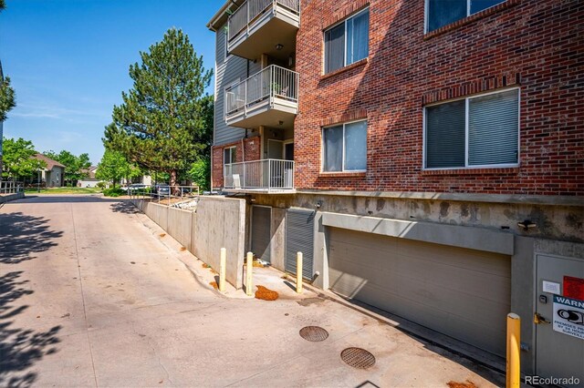 2895 W Riverwalk Cir Unit 104, Littleton, CO 80123 - view of building exterior with an attached garage and driveway