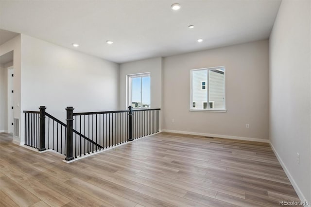 empty room with recessed lighting, visible vents, light wood-style flooring, and baseboards