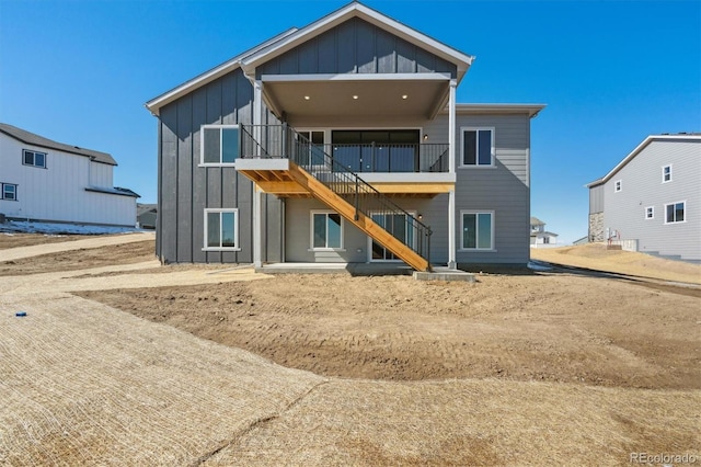 back of property featuring stairs and board and batten siding