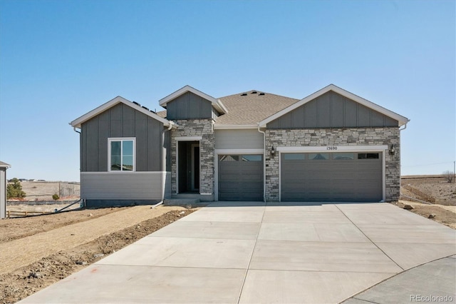 view of front facade with driveway, stone siding, board and batten siding, and an attached garage