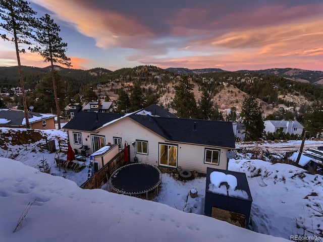 snow covered house featuring a mountain view