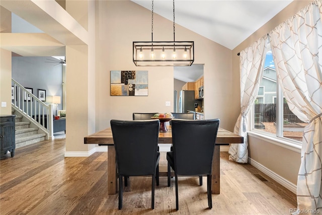 9756 Quay Loop, Broomfield, CO 80021 - dining space featuring light wood finished floors, baseboards, plenty of natural light, stairs, and high vaulted ceiling