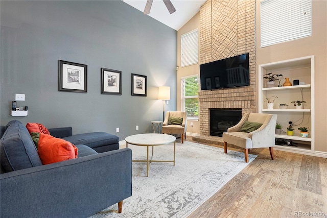 9756 Quay Loop, Broomfield, CO 80021 - living room with high vaulted ceiling, a fireplace, wood finished floors, ceiling fan, and built in shelves