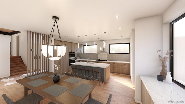 dining space with light wood-type flooring and sink