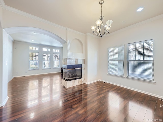 living room with ornamental molding, a notable chandelier, dark hardwood / wood-style floors, and a fireplace