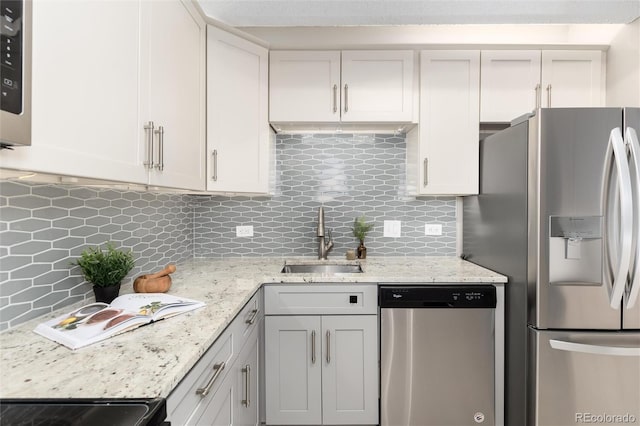 555 E 10th Ave Unit 206, Denver, CO 80203 - kitchen featuring stainless steel appliances, backsplash, and light stone counters