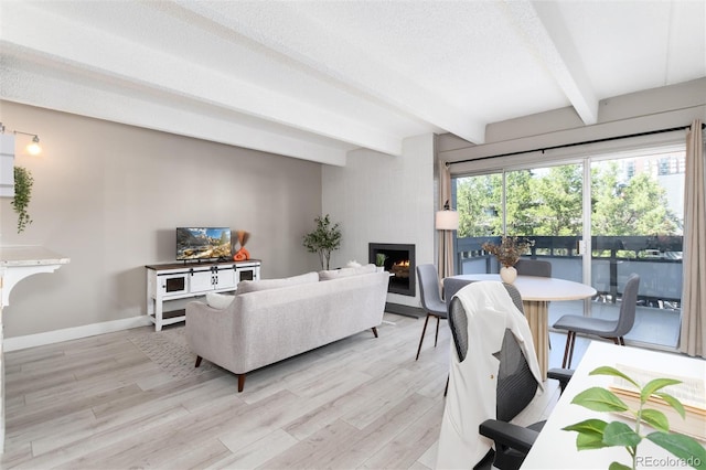 555 E 10th Ave Unit 206, Denver, CO 80203 - living room with a large fireplace, beam ceiling, and light wood finished floors